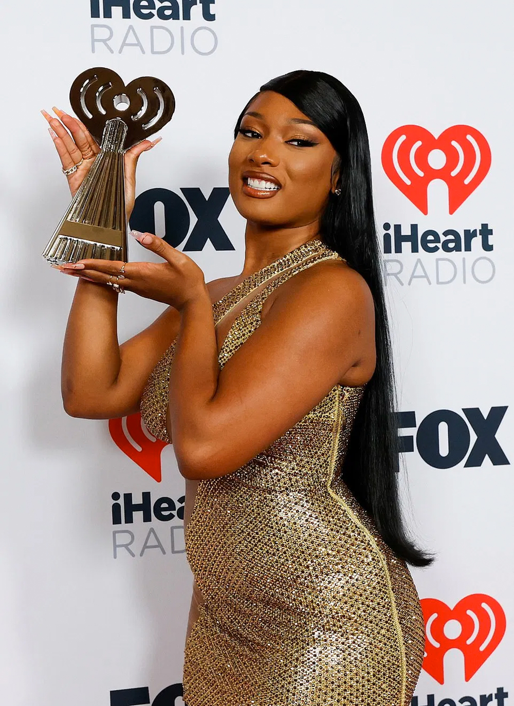 Megan Thee Stallion is golden vision in this dress a the IHeart Music